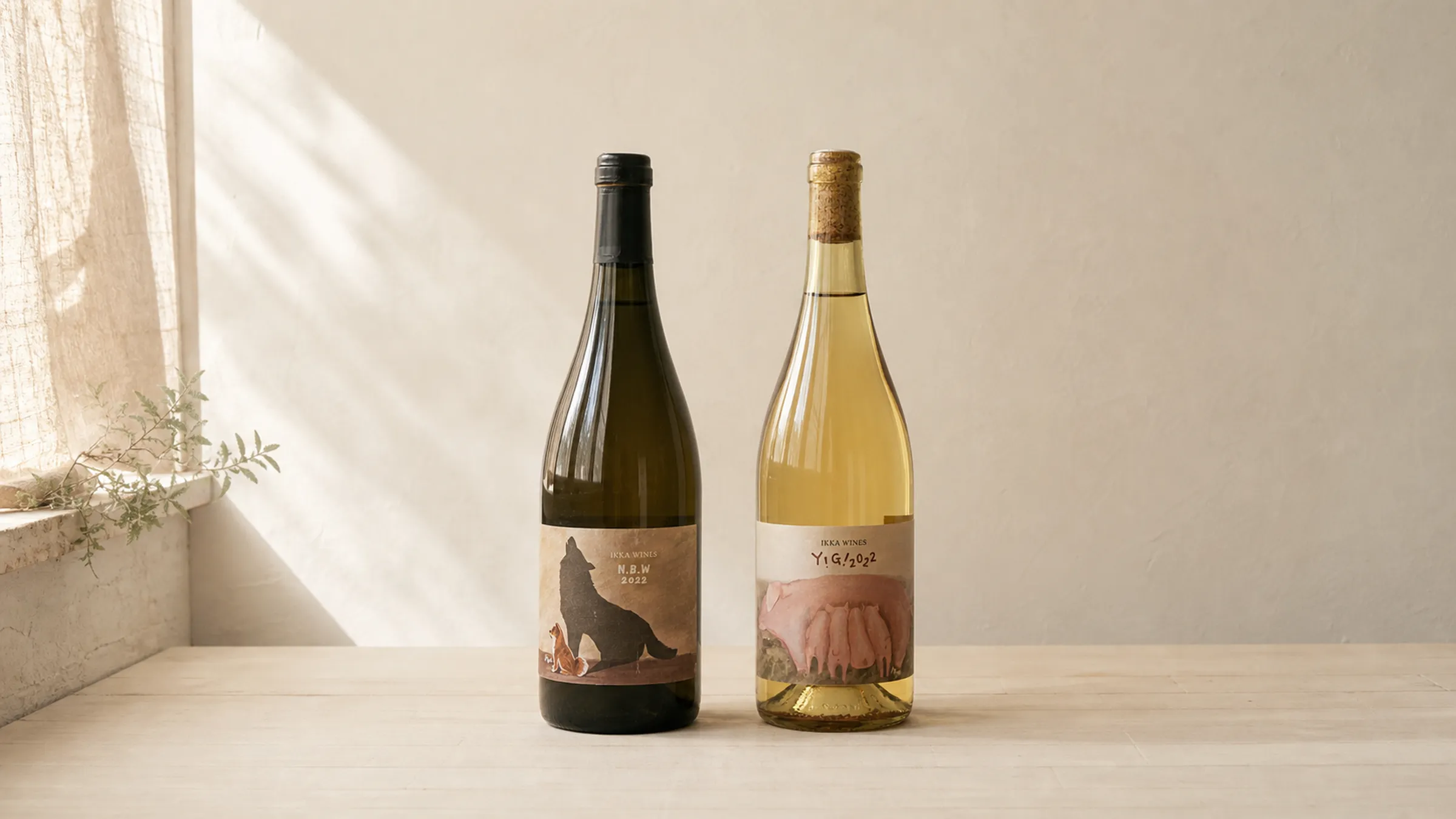 IKKA WINES Y!G! and N.B.W bottles shown fully in a quiet Japanese natural-light studio scene