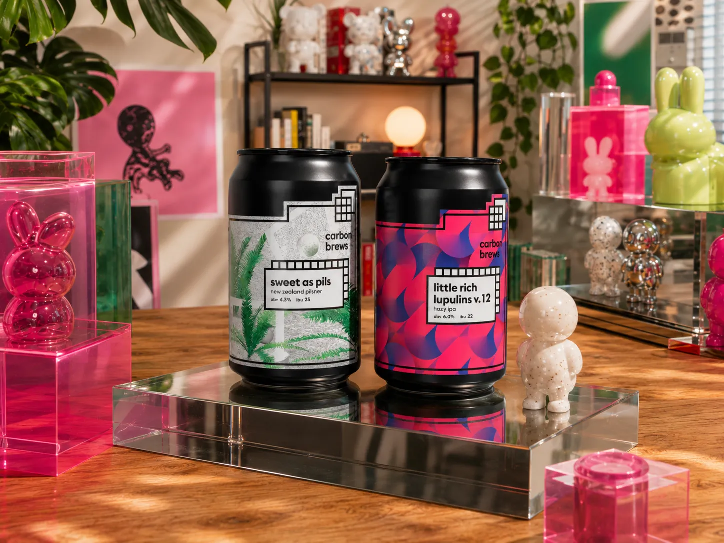 Carbon Brews two cans shown together on a reflective tray in a studio scene
