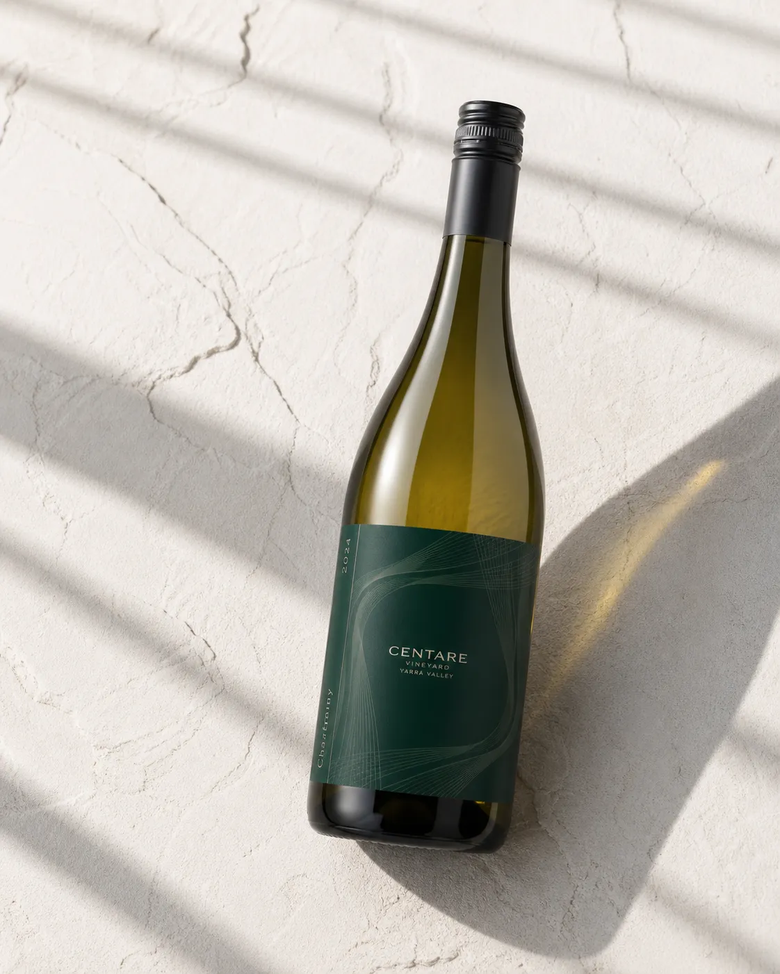 CENTARE Chardonnay bottle in a pale abstract studio with fine linear shadows