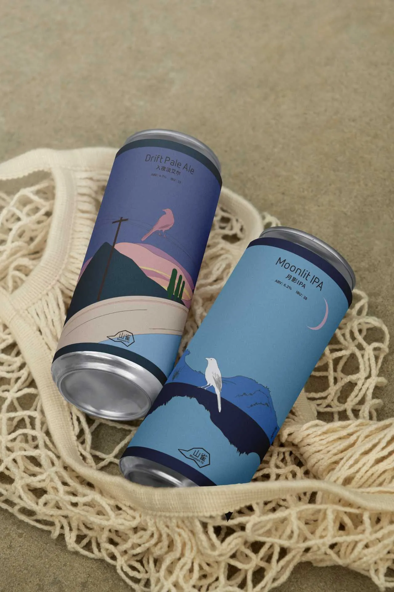 Two Mountain Tit cans laid together on a woven textile to show the series relationship